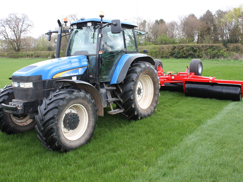 Front view of 6.3m HE-VA hydraulic-folding Grass Rolls behind a New Holland tractor