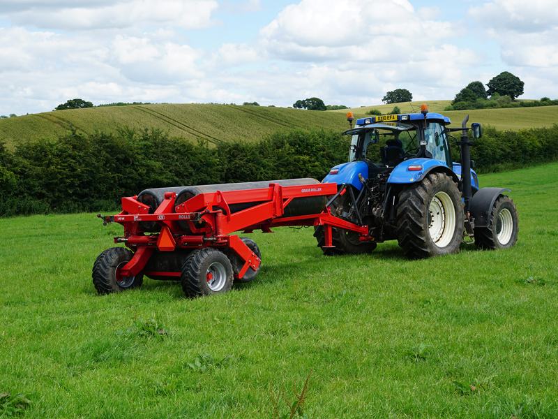 8.2m HE-VA hydraulic-folding Grass Rolls behind a New Holland tractor in transport position