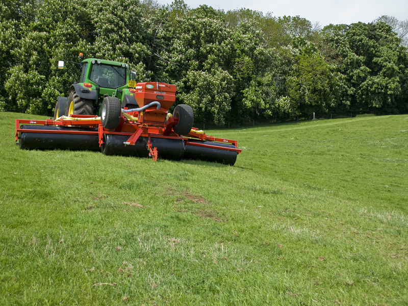 John Deere tractor towing a HE-VA Grass Roller unfolded
