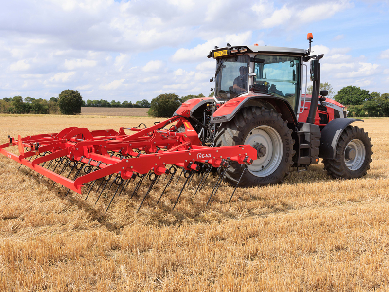 Side view of 6m HE-VA Top Strigle straw harrow mounted to a Massey Ferguson tractor