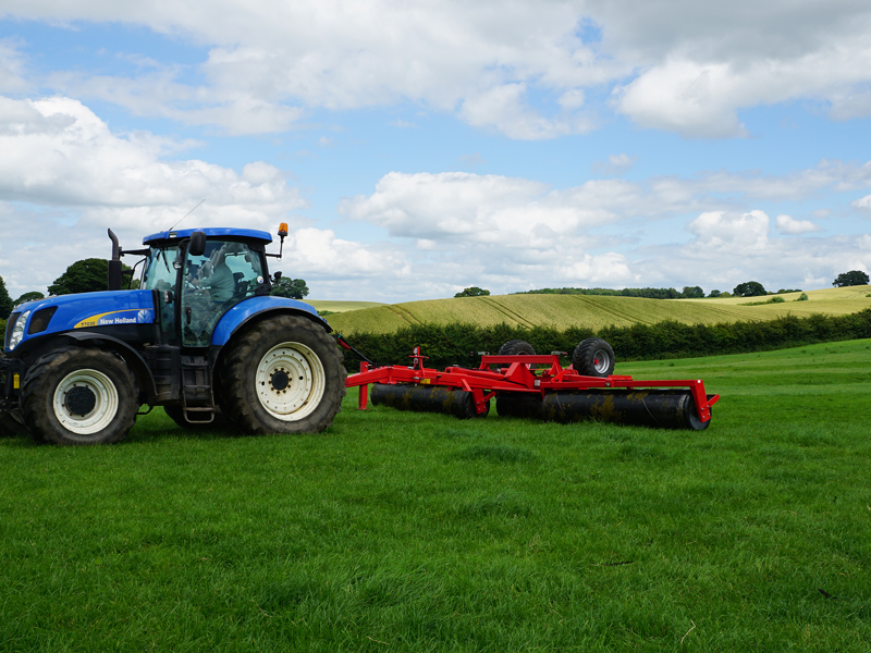 8.2m HE-VA hydraulic-folding Grass Rolls behind a New Holland tractor in working position