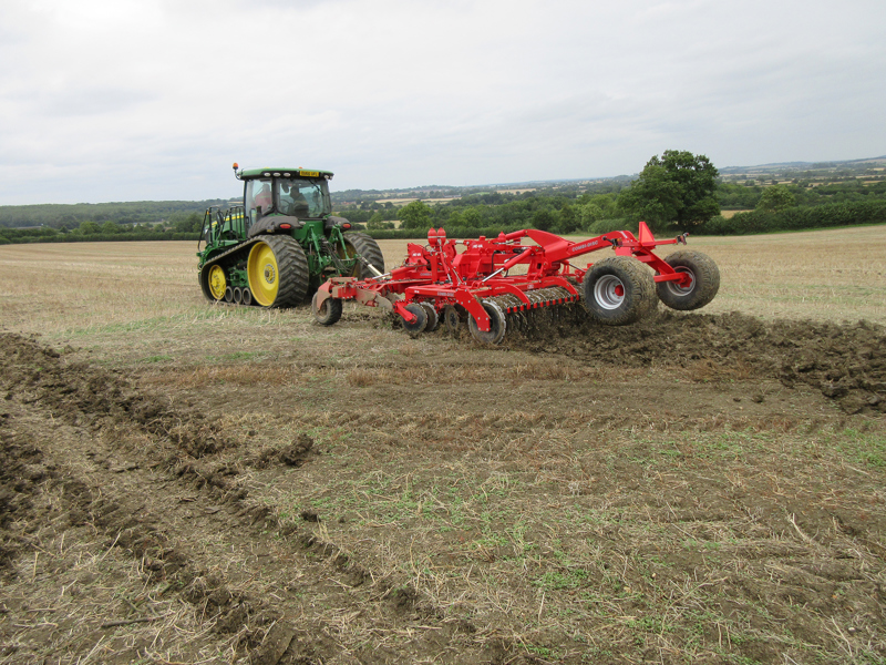 Trailed, hydraulic-folding HE-VA Combi-Disc working behind a John Deere tracked tractor
